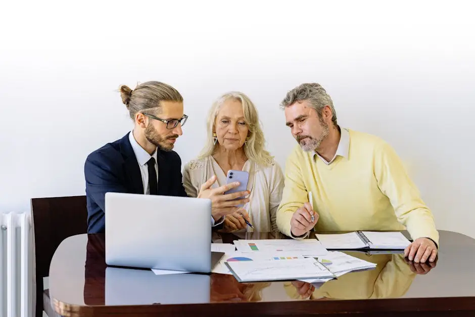 Home Three individuals collaborating on financial documents during a business meeting.