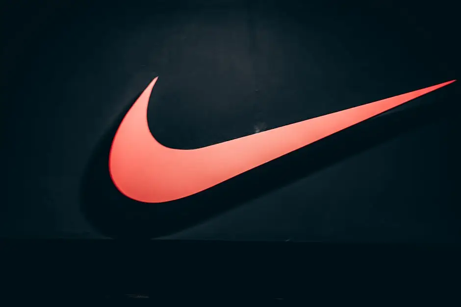 Home Vibrant red Nike swoosh logo displayed on a dark, minimalist backdrop symbolizing sports and lifestyle.